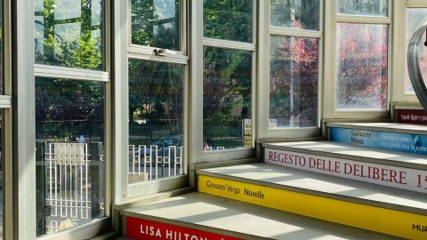 scala all'interno della biblioteca. Sui gradini sono stampati vari generi letterari